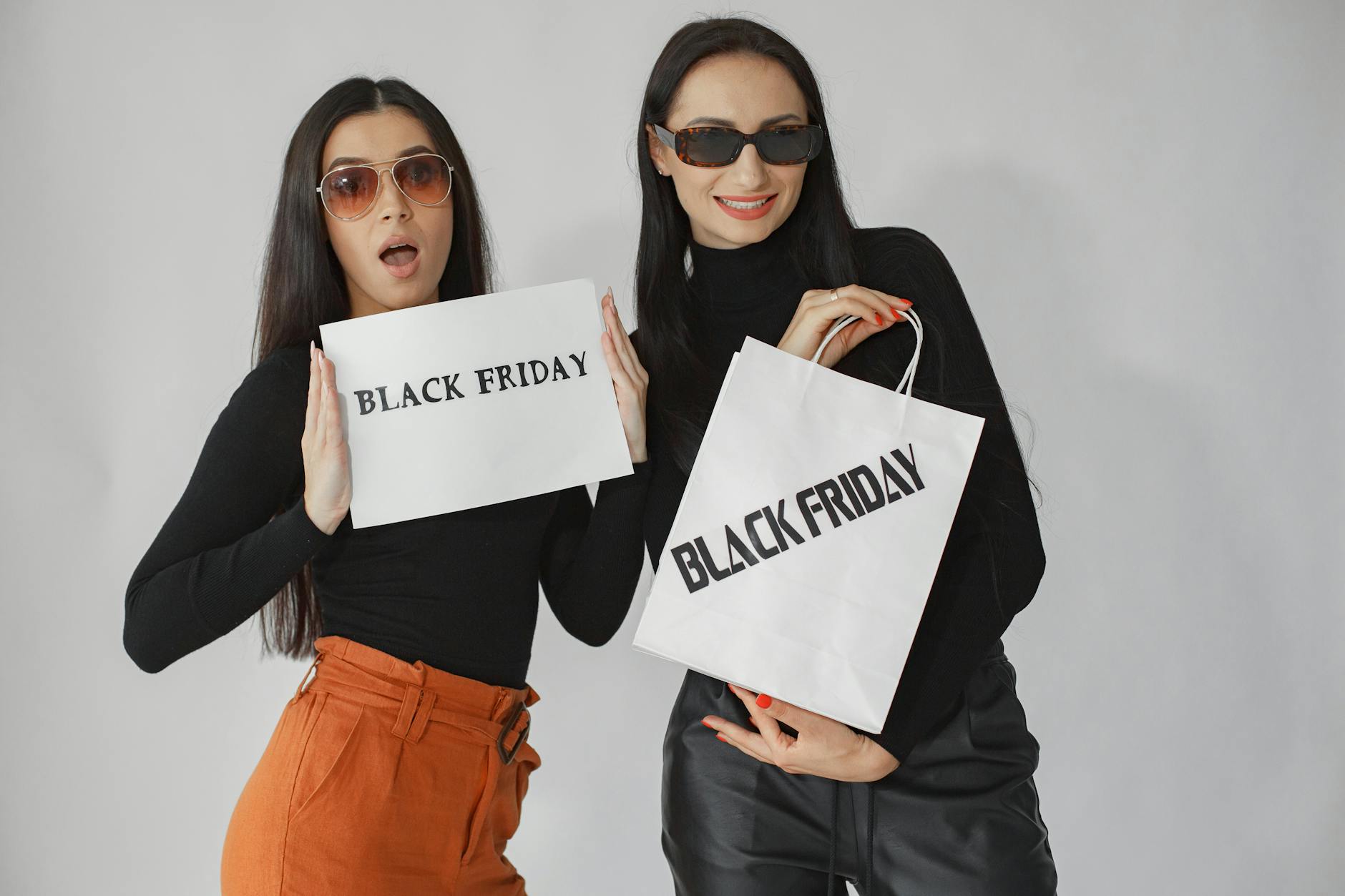 Dwie eleganckie kobiety z torbami zakupowymi Black Friday