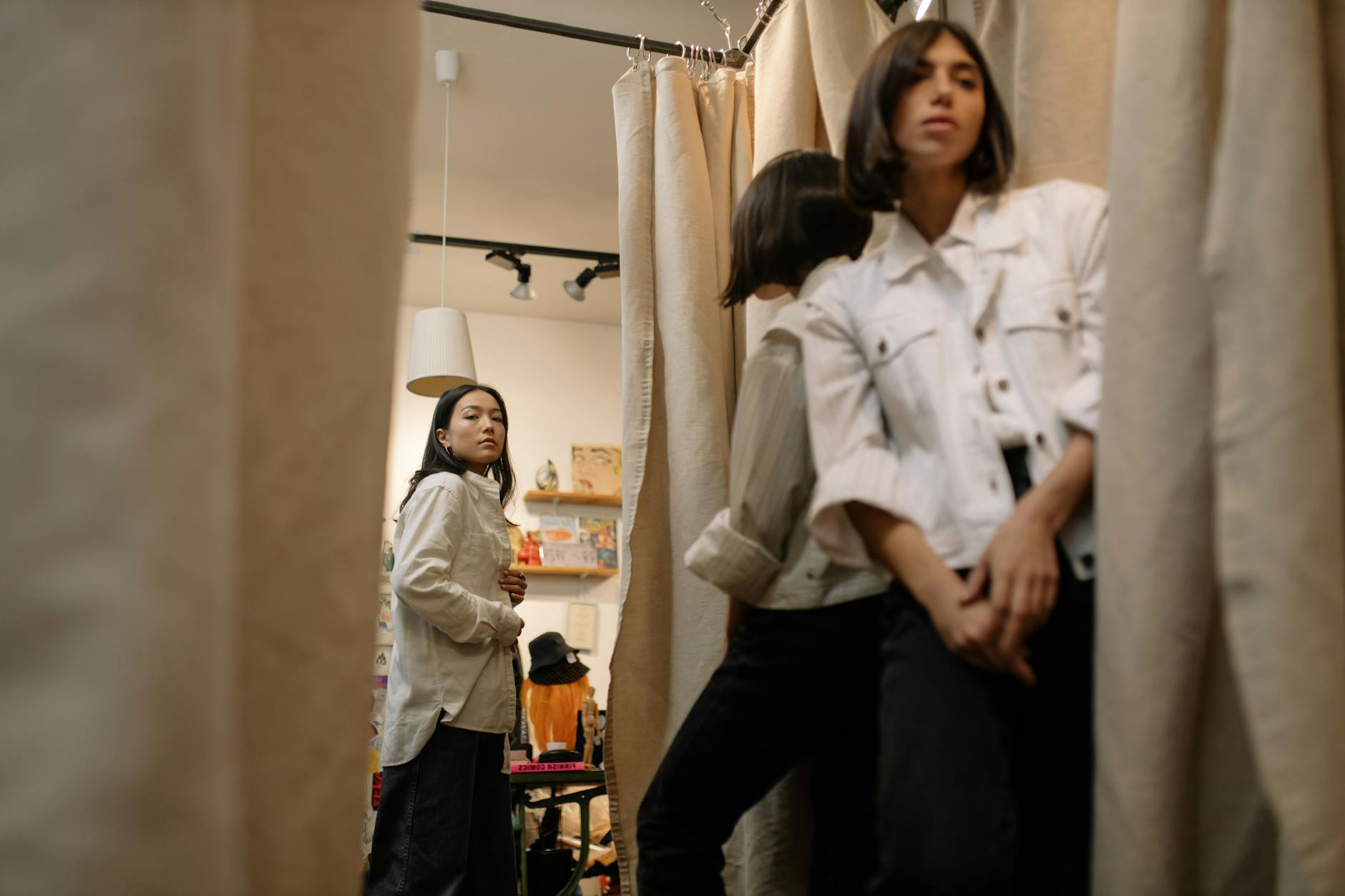 Kobieta mierzy kurtkę puchową w przymierzalni z lustrami