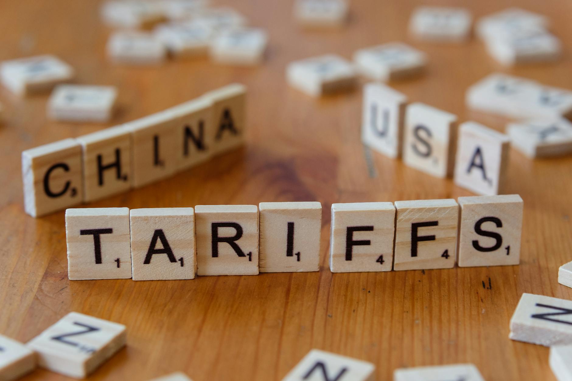 Drewniane klocki z napisami tariffs, China i USA symbolizujące relacje handlowe