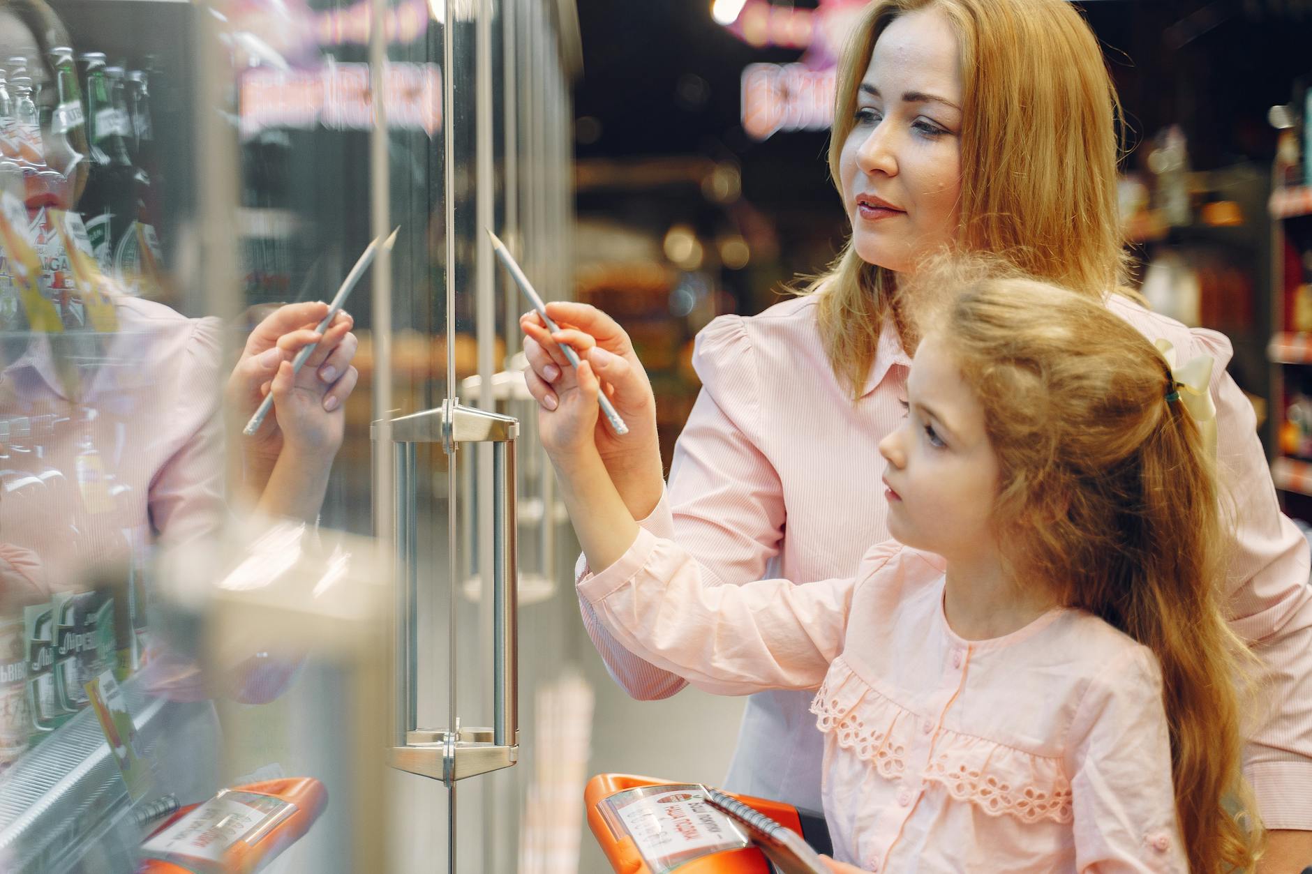 Mama z córką wybierają produkty w alejce supermarketu