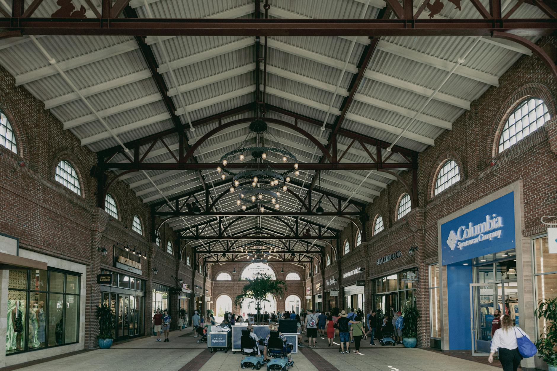 Jak odróżnić prawdziwy outlet od sklepu „z przecenami” Klienci spacerujący po nowoczesnej galerii handlowej z podwieszanym oświetleniem