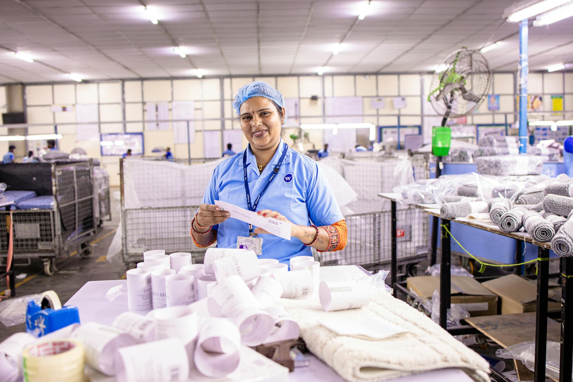 Pracownica fabryki odzieży sprawdza metki pod kątem oryginalności