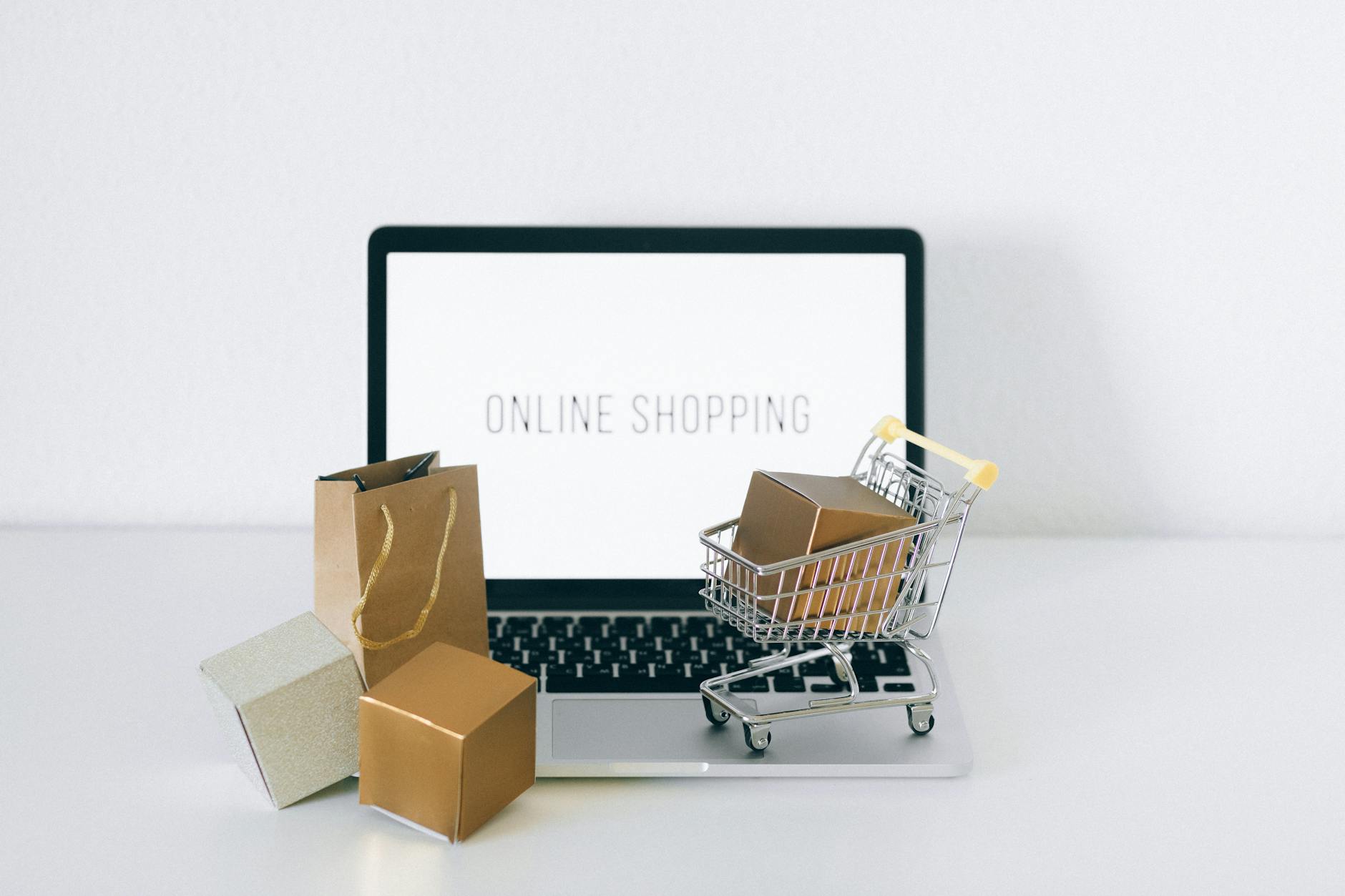 Laptop z ekranem zakupów online i kartonowymi pudełkami obok