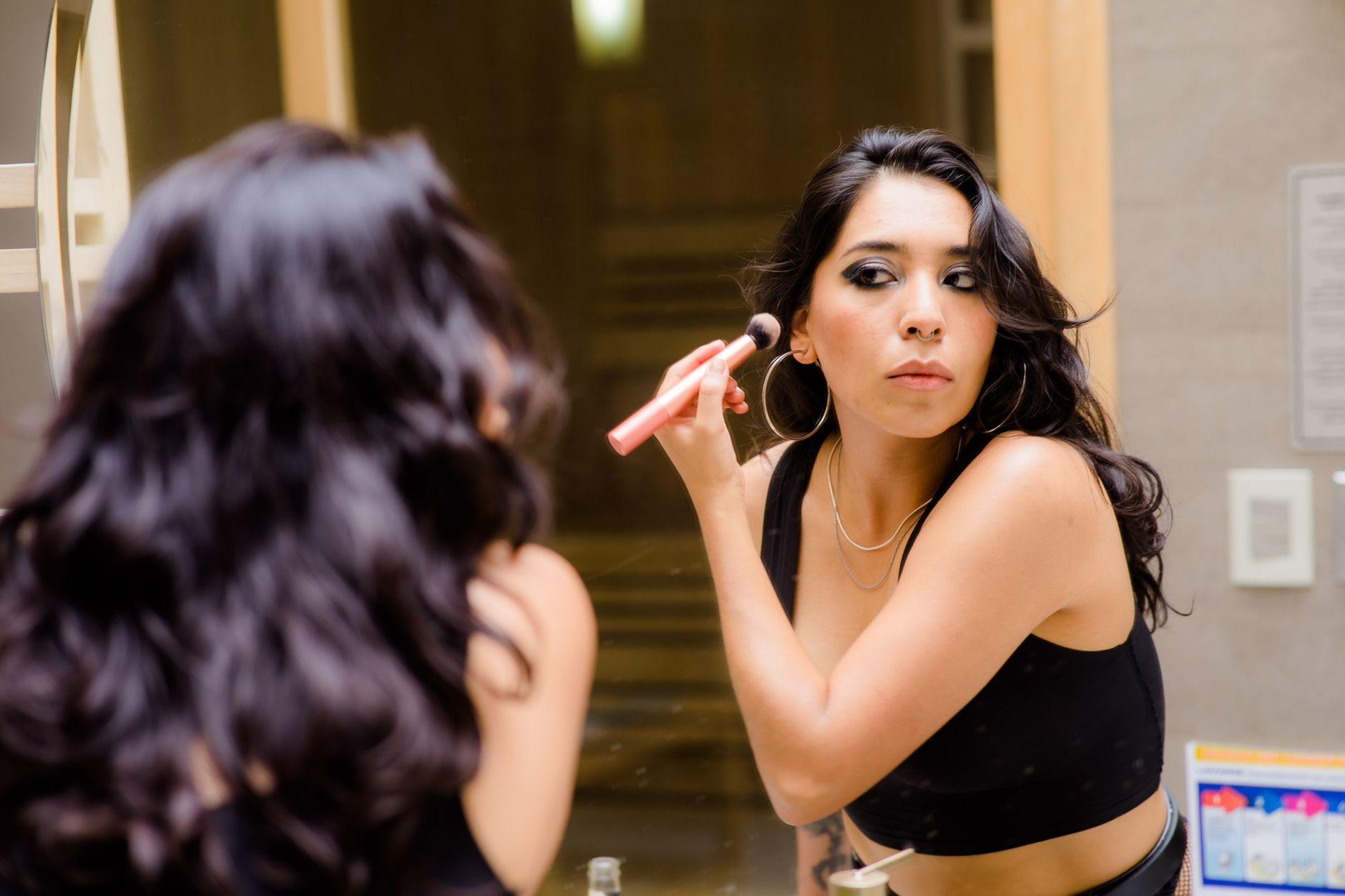 Brunetka wykonuje naturalny makijaż konturujący twarz w domu