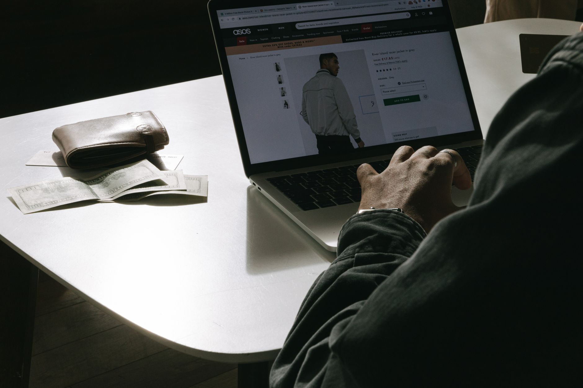 Outlet online bez ryzyka: 9 sygnałów, że sklep jest podejrzany Mężczyzna kupuje ubrania w internetowym outlecie na laptopie